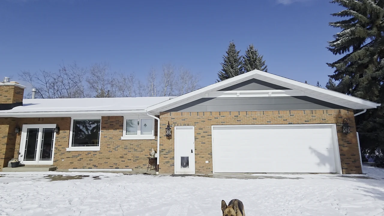 Brick bungalow in winter with white fascia and eavestrough along the garage roof