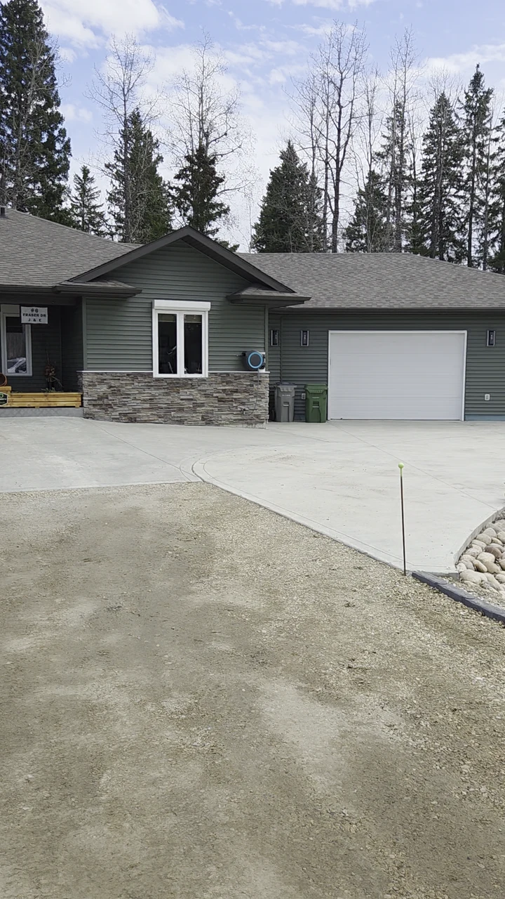 Country bungalow with grey siding, stone accents and an attached garage