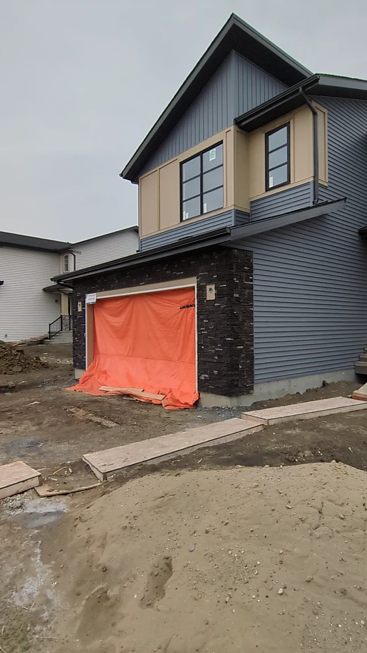 Front view of the grey siding project with contrasting panels and a dark roofline