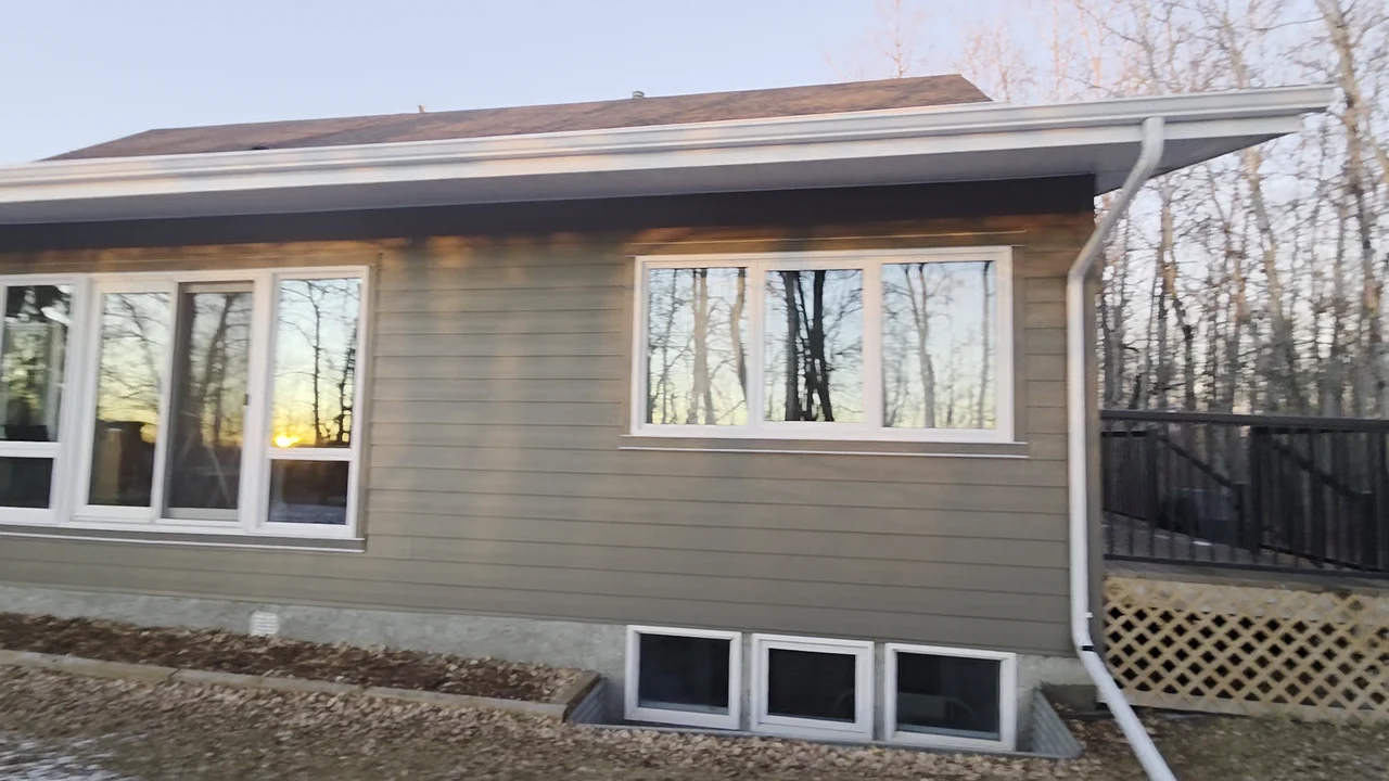 Lap siding and white window trim along the rear of a home