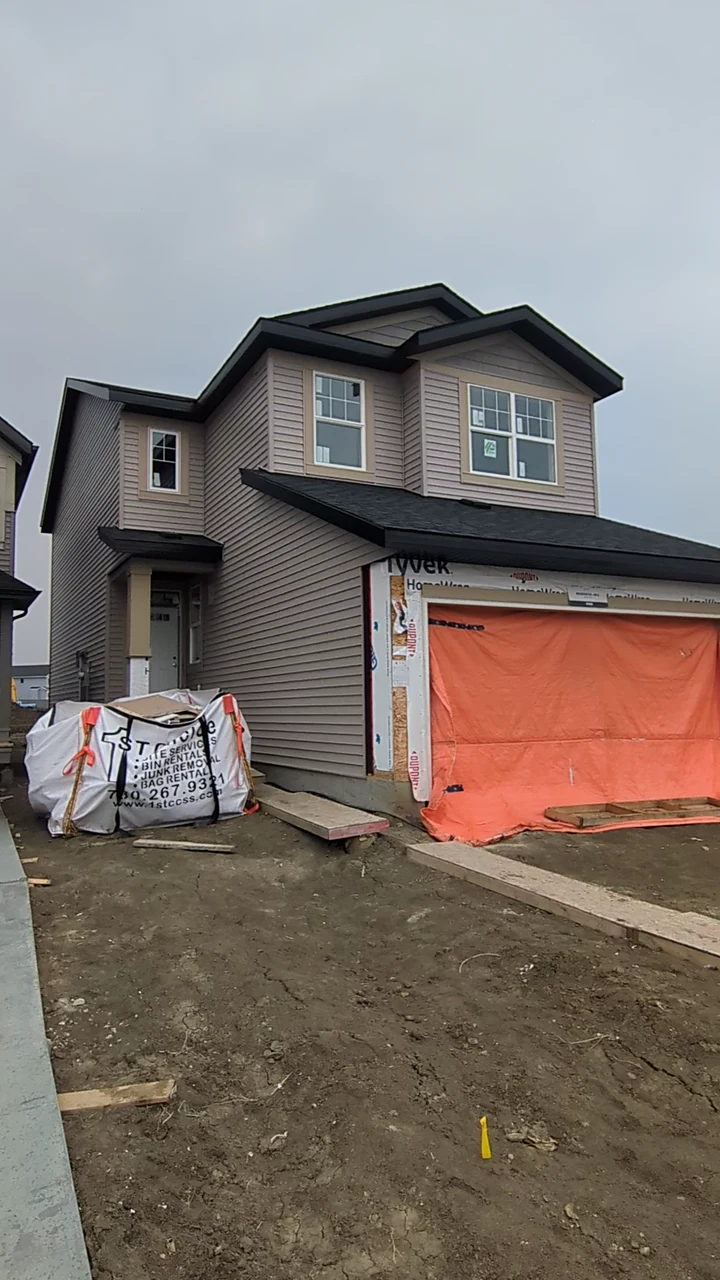 Taupe siding and a dark roofline on a two-storey home under construction