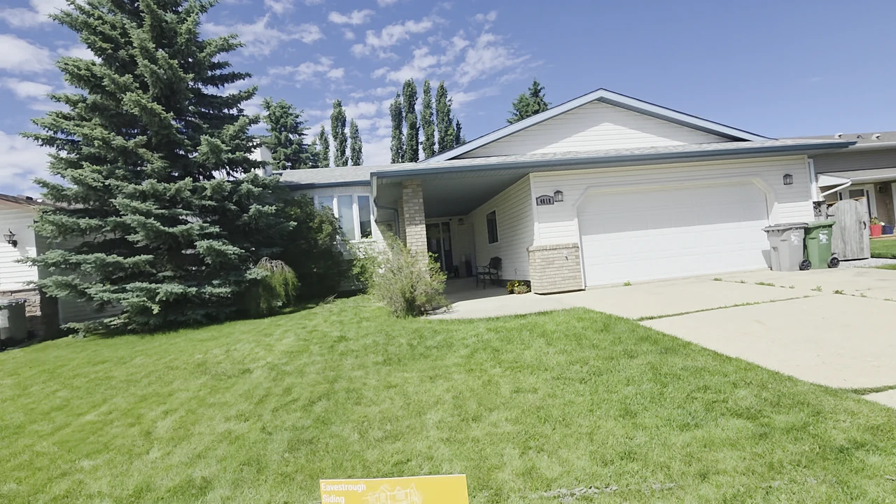Light-sided bungalow with an attached white garage and green front lawn