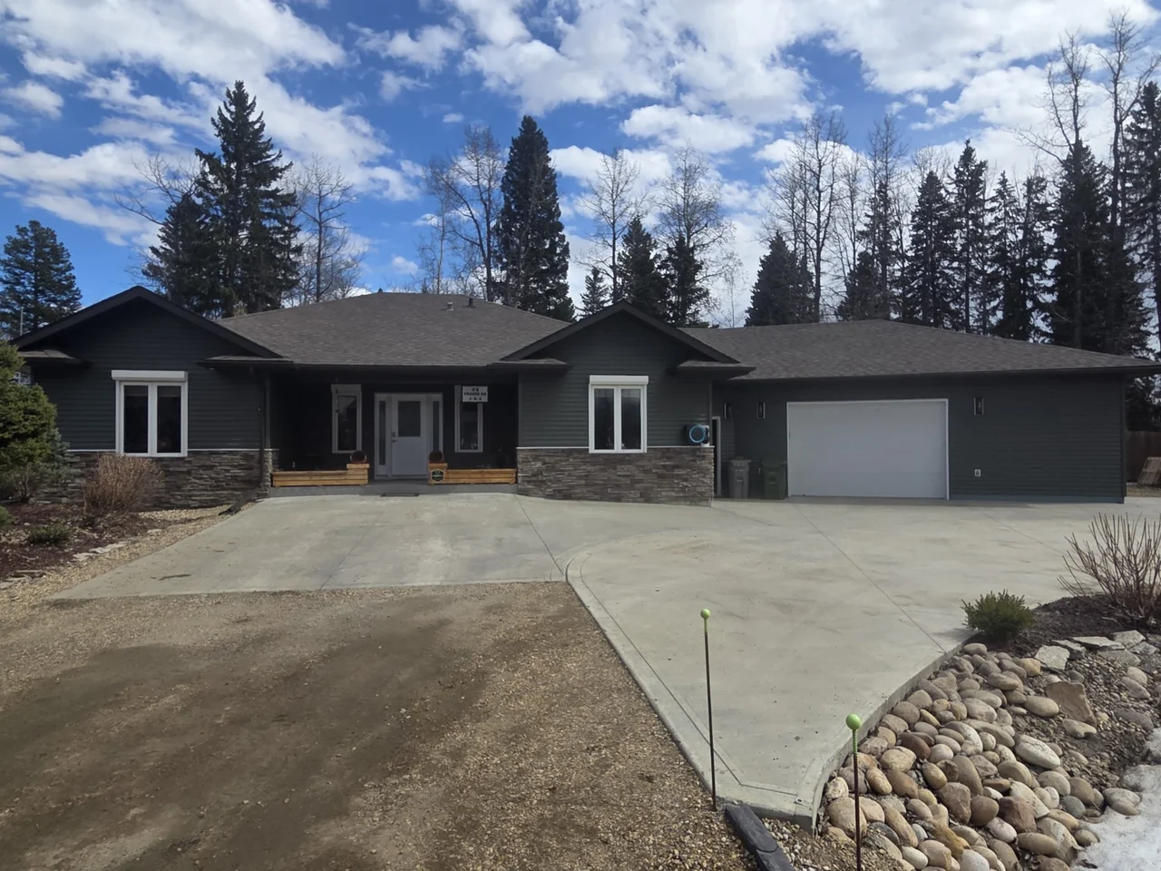 Charcoal siding across a bungalow and attached garage with white window trim