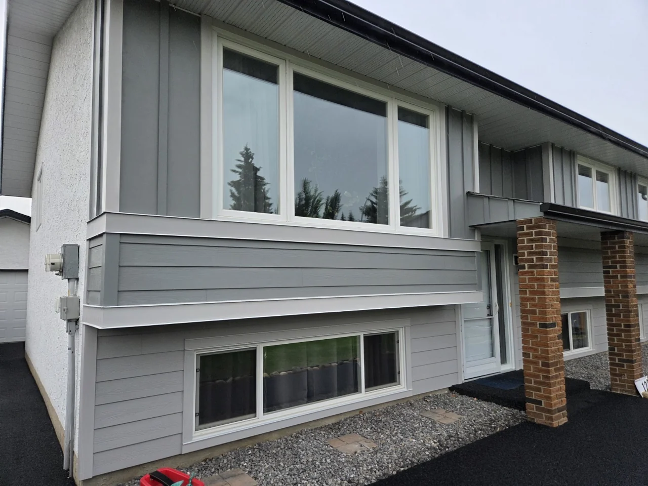 Grey Hardie lap siding, vertical accents and white window trim on a Front-Line project