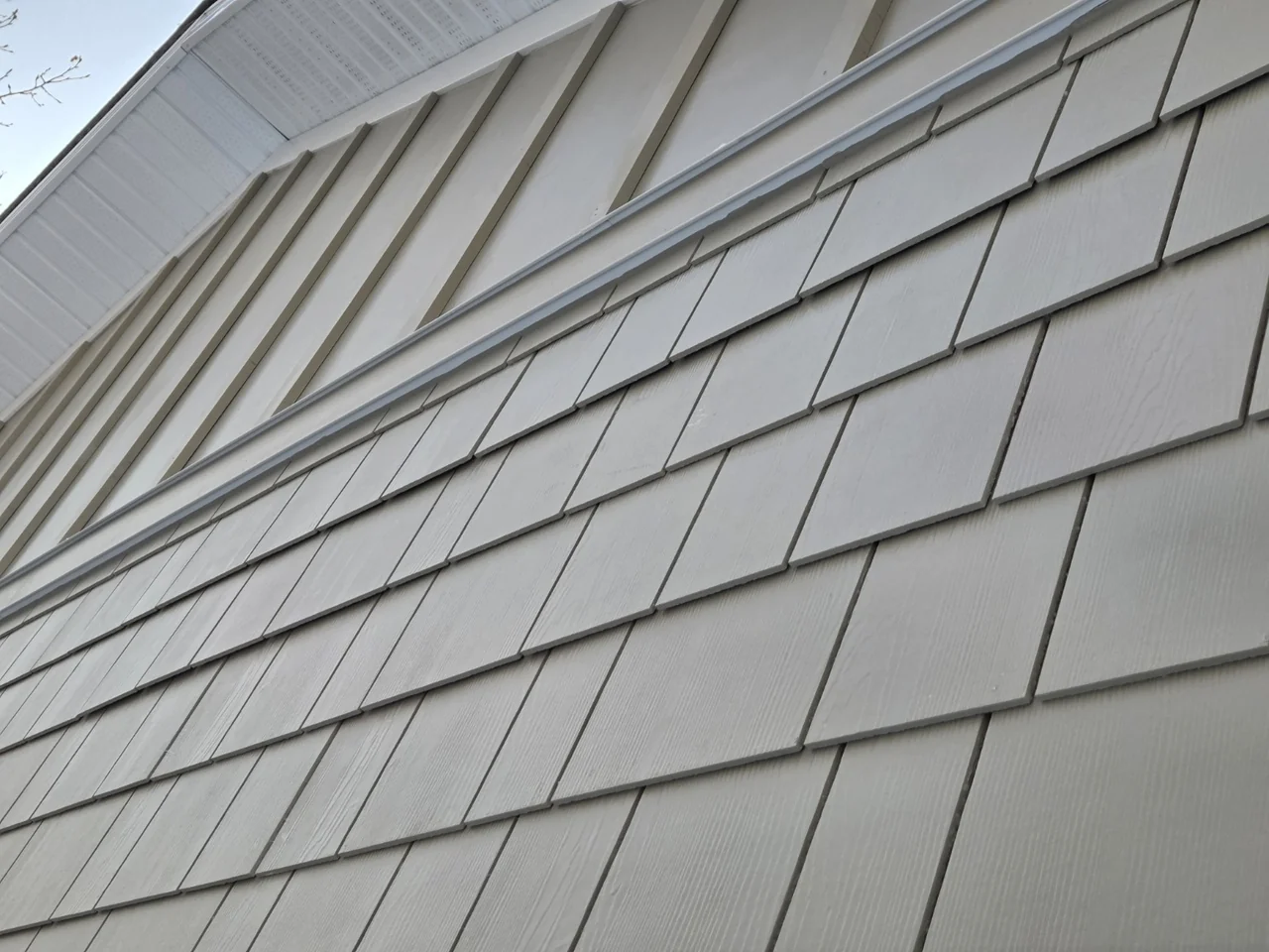 Shingle-profile siding with horizontal trim and a vertical accent above
